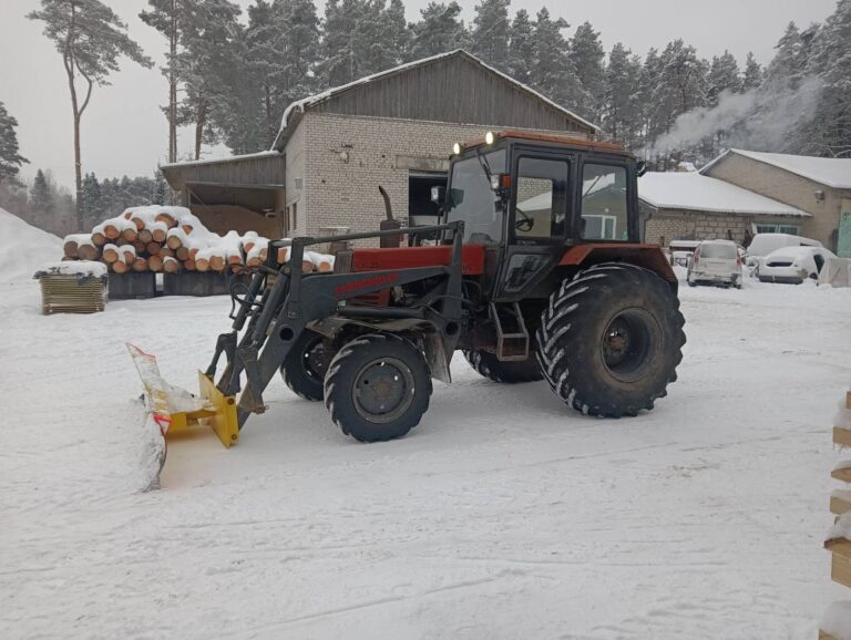 Lumelükkamine Puiduladu laoplatsil, traktor esilaaduri ja sahaga